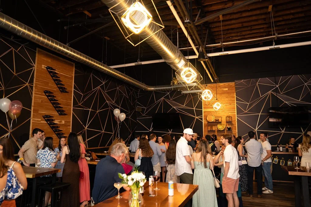 The room mid-celebration — warm lighting, full floor, guests throughout