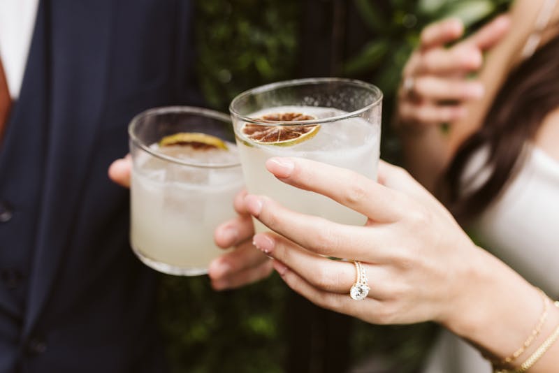 Couple toasting with cocktails at engagement party
