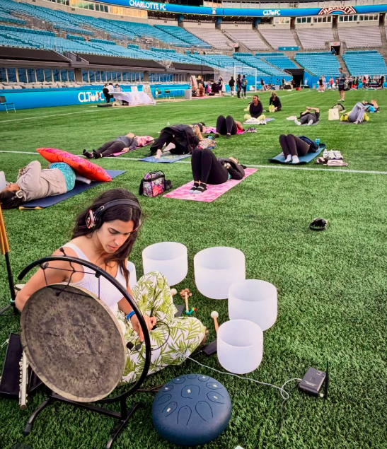 Esti of Serenity Waves Co. leading a sound bath at Bank of America Stadium