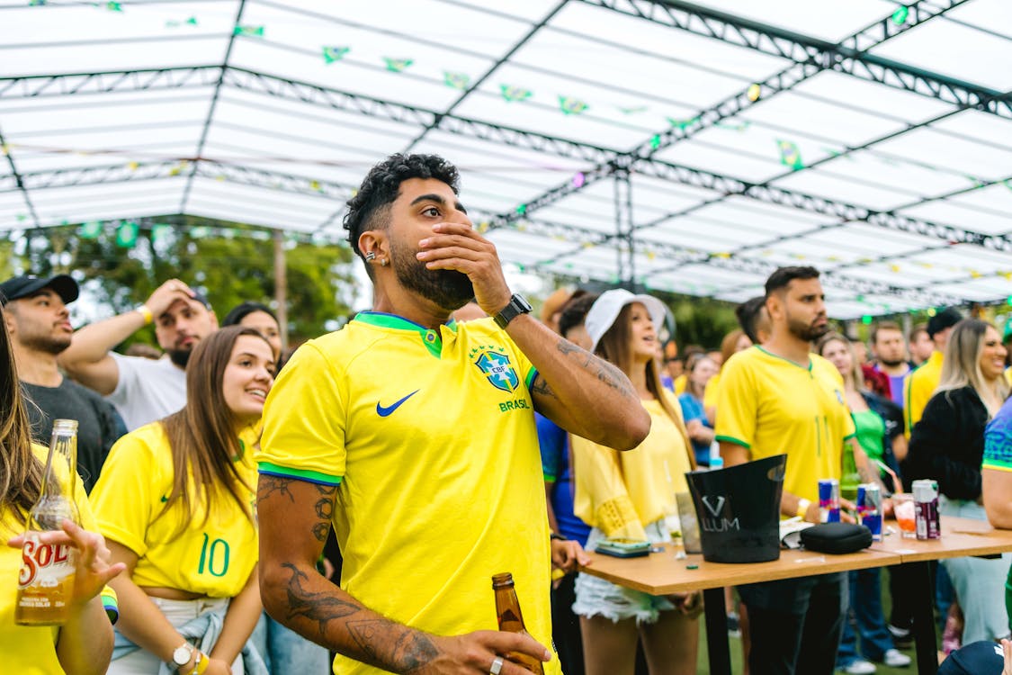 Soccer fans in jerseys watching the game at a bar